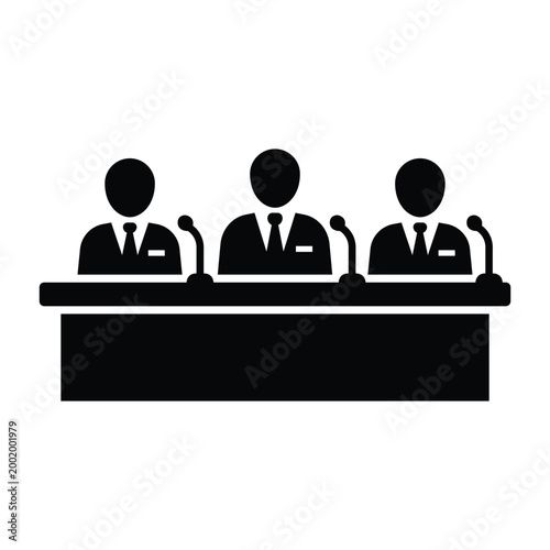 Three businessmen at press conference panel desk with microphones solid black icon for media event
