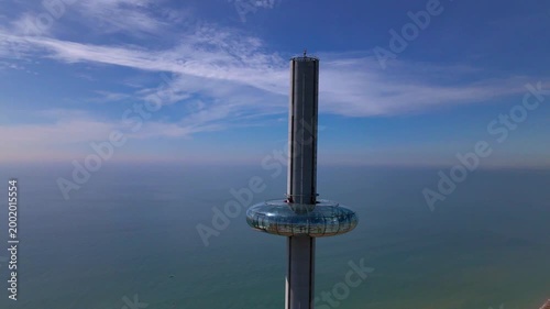 Close up aerial orbit of Brighton i360 observation pod with changing backdrop