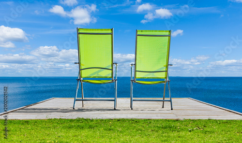 Zwei grüne Stühle am Strand