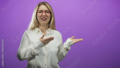 Bild auf Leinwand Woman wearing red glasses holds palms up and gestures questioning with open hands in studio; confusion