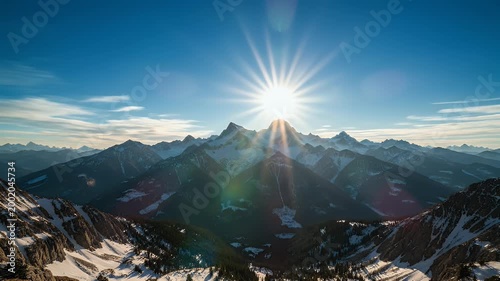 A breathtaking panoramic view captures a majestic mountain range bathed in the warm hues of a vibrant sunset, showcasing snow-capped peaks and a dramatic sky.