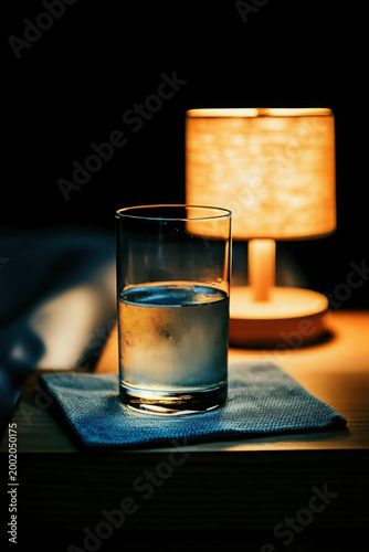 Glass of Water Next to Nightstand Lamp in Cozy Dim Lighting