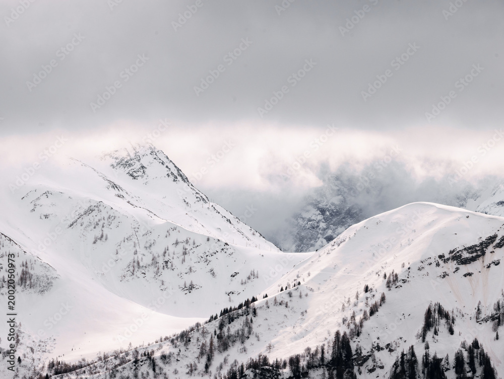 Obraz premium Pastel Winter Mountains Beneath Storm Clouds