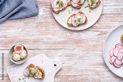 Rustic buckwheat baguette topped with homemade labneh and sliced radishes. Seasonal healthy vegetarian natural spring light toasts