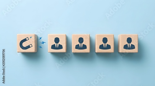 Magnetic force attracting talent recruitment icons on wooden square blocks.