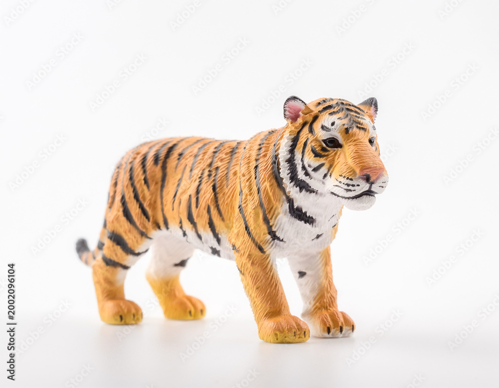 Obraz premium A realistic tiger figurine standing against a white background, capturing the majesty and ferocity of the animal in detail