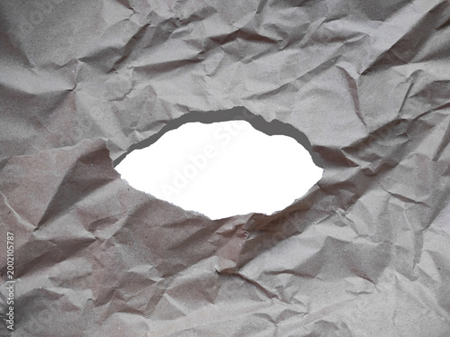 Torn kraft paper with a realistic hole and rough ripped edges, featuring natural inner shadow and crumpled texture. Empty copy space for text or design elements. Isolated on transparent background. Pe