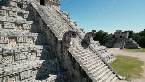 The majestic pyramid of Chichen Itza rises against a clear blue sky, showcasing ancient Mayan architecture.