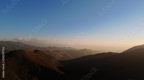 Imagens aéreas cinematográficas das montanhas da Serra da Mantiqueira, com sol de final do dia refletindo nos vales e criando um cenário natural impressionante.