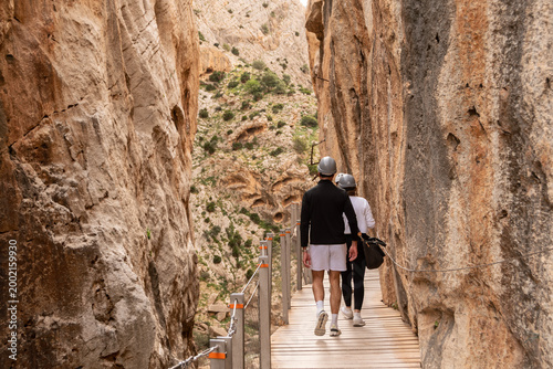 Pareja caminando por el Caminito del Rey entre paredes rocosas