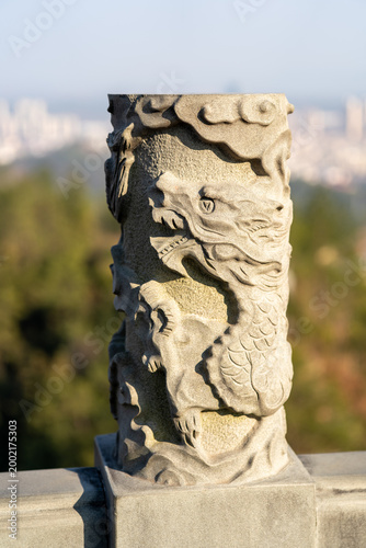 Fotografía Una estatua de un ángel decorativo destaca bajo el cielo azul junto a monumentos
