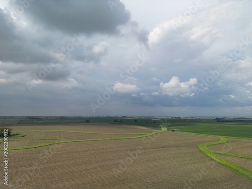 The cloud start to darken over the farm fields of western Illinois as the thunderstorms become powerful enough to storm. Big bold skies seen from a drone.