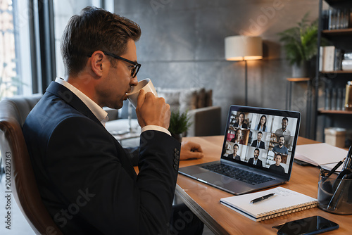 Businessman working on laptop in modern office with corporate technology environment