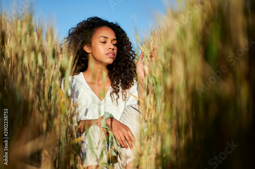 Young woman enjoying nature in golden wheat field