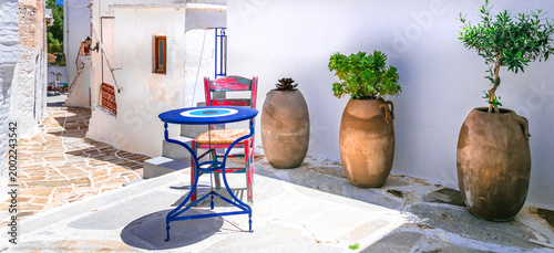 Lefkes Paros Greece, Traditional Village Narrow Street with Blue Chairs and Round Table, Ancient Clay Amphora Vases on White Walls, Authentic Cycladic Mediterranean Aesthetics Summer Travel