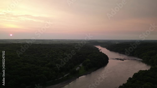 Seeing the sun on a haze day sunrise over a natural tree parkland in Linn County, Iowa. Palisades State Park.  4k, drone, flying
