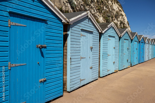 Vászonkép Row of Blue Beach Huts on Sunny Seaside Promenade