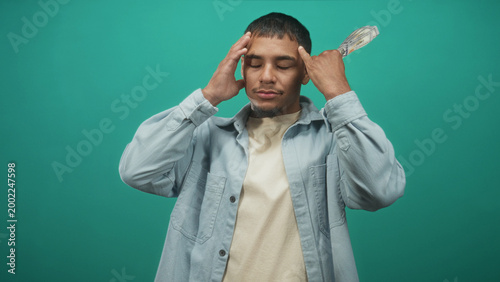 Принти на полотні Man holding fanned us dollar bills by his face in studio, gesturing and closing eyes in boastful display; confidence
