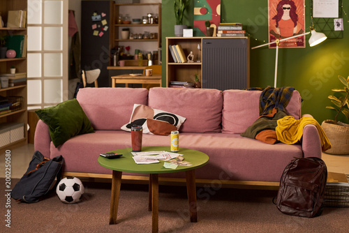 Bild auf Leinwand Wide shot of student living room showing backpacks, soccer ball, study books, bills, and drinks, illustrating busy college routine