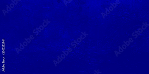 Dark blue grunge texture background with vignetting, abstract navy blue mottled wall surface