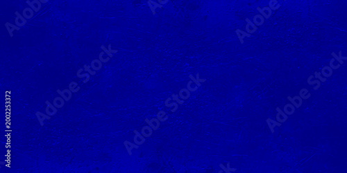 Dark blue grunge texture background with vignetting, abstract navy blue mottled wall surface