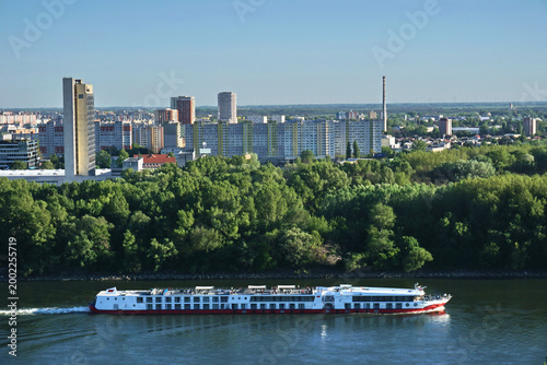 Photography White cruise ship on Danube river in Bratislava with city skyline and Petrzalka district buildings