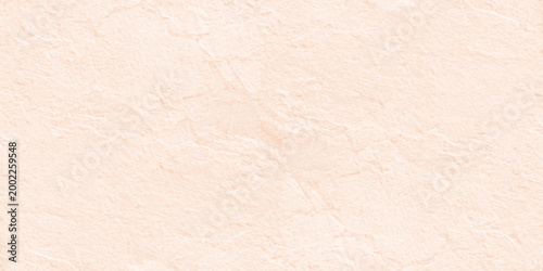 Pale peach textured stone wall background with subtle grain and natural plaster finish for minimalist interior design