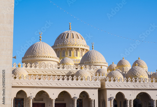 Ornate white marble domes and intricate Islamic architecture of Al Mina Mosque in Hurghada, Egypt.