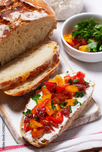 Bruschetta from homemade bread with cottage cheese and sprat pate and tomatoes on a wooden background. Rustic style.
