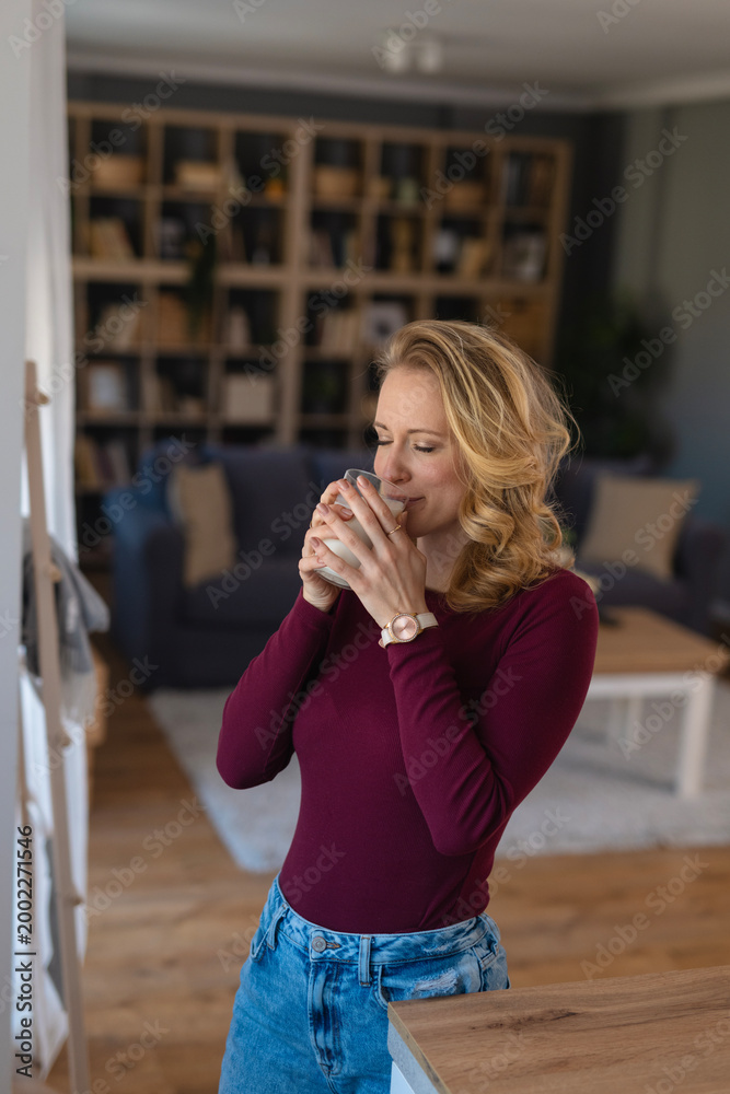 Fototapeta premium Woman enjoying warm drink at home in morning