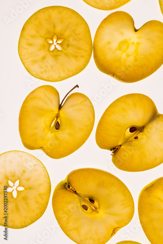 Golden apple slices on light background, flat lay pattern
