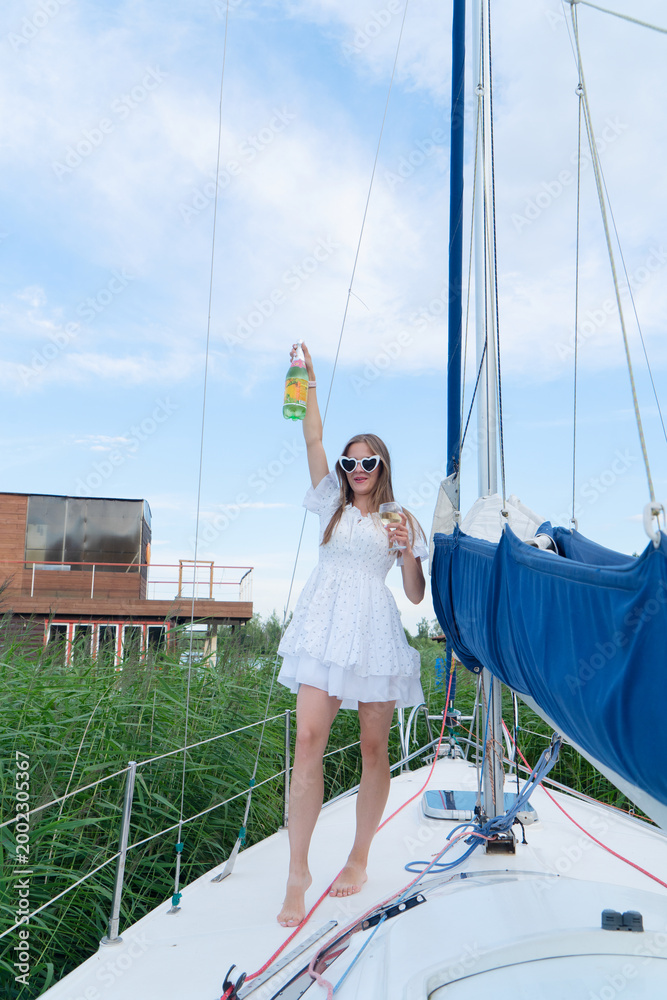 Obraz premium A joyful woman is celebrating by the peaceful water, holding vibrant flowers and enjoying the beautiful view around her