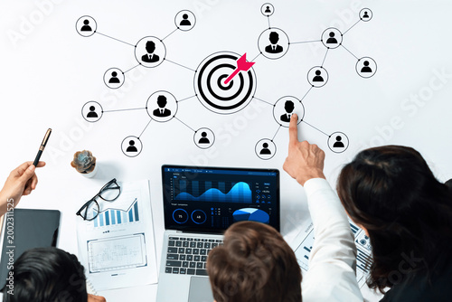 Cuadro en lienzo A team collaborates over a laptop displaying data analytics with a focus on target marketing and networking, surrounded by business charts and graphs