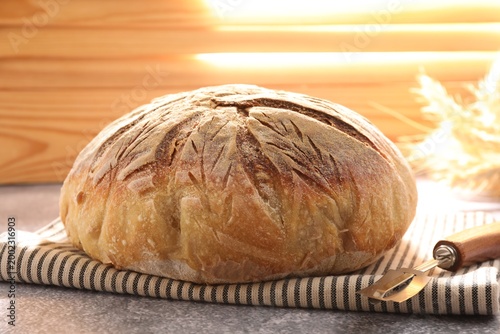 Εκτύπωση καμβά Loaf of freshly baked bread, lame and spikes on grey table, closeup