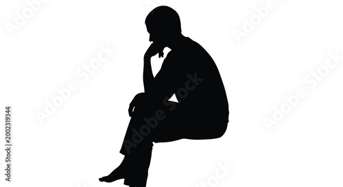 Silhouette of a man sitting in a thoughtful pose with his hand on chin