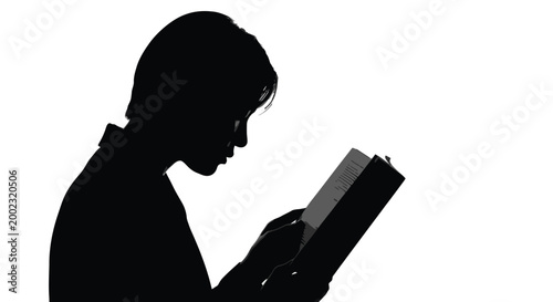 Silhouette of a person reading a book with focused attention on the text content closely