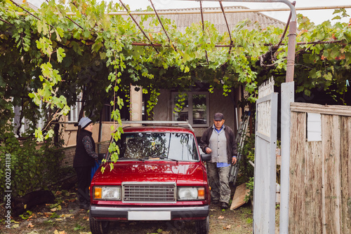 A senior Caucasian man and woman prepare to get into an older car.