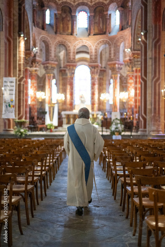 Canvas-taulu Prêtre marchant dans l'allée centrale d'une église vers l'autel