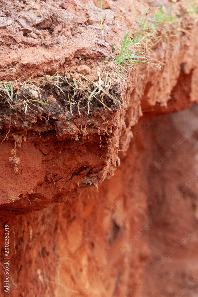 Fototapeta premium Excavation in red soil with ground cutting for foundation preparation at a construction site.