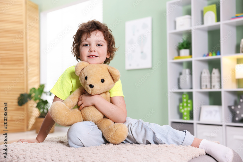 Ταπετσαρία Smiling little boy hugging plush toy bear on pouf at home