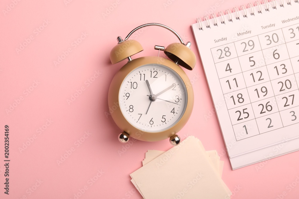Obraz premium Reminder. Alarm clock, sticky notes and calendar on pink background, flat lay. Space for text