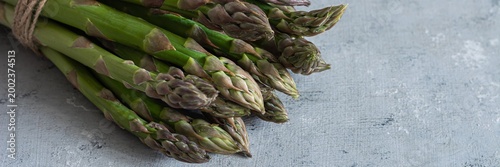 Raw green asparagus on a blue background. Raw food concept, place for copy space.