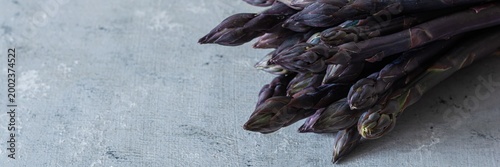 Raw purple asparagus on a blue background. Raw food concept, place for copy space.