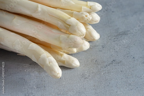 Raw white asparagus on a blue background. Raw food concept, place for copy space.