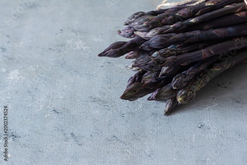 Raw purple asparagus on a blue background. Raw food concept, place for copy space.