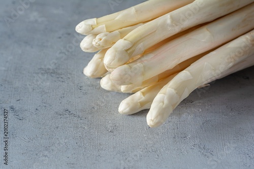 Raw white asparagus on a blue background. Raw food concept, place for copy space.