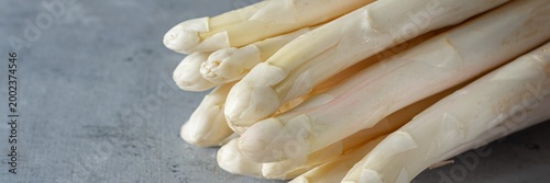 Raw white asparagus on a blue background. Raw food concept, place for copy space.