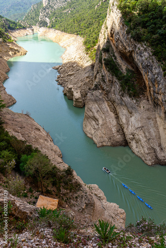 Aerial view of turquoise river canyon with kayaks and boat in limestone gorge