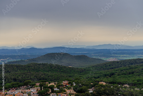 Panoramic view of Mediterranean village with forested hills and mountains