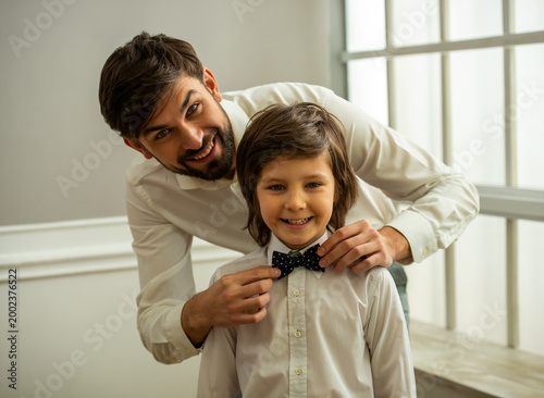 Father adjusting child bow tie.